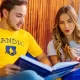 Alunos da Faculdade Mandic estudando juntos com livros acadêmicos em ambiente universitário